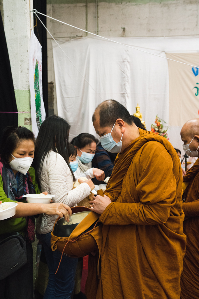 Mönch bekommt Reis von seiner buddhistischen Gemeinde geschenkt.